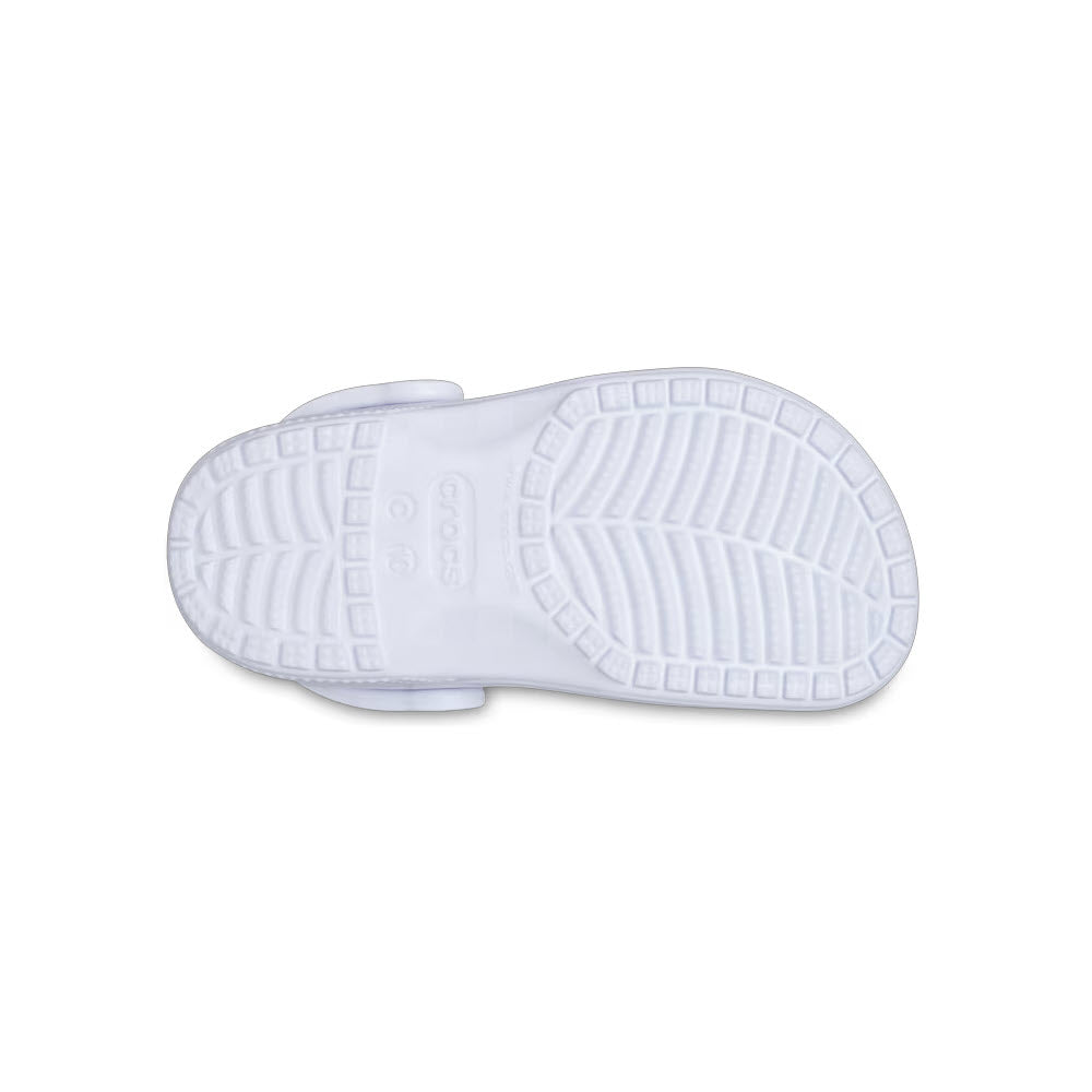 Bottom view of a single white kids&#39; Crocs shoe showing its textured sole.