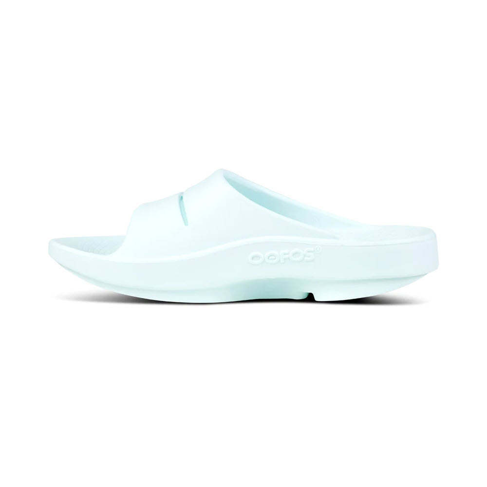 Light blue OOFOS OOFOS OOAHH ICE - WOMENS brand recovery slide sandal featuring OOfoam technology isolated on a white background.