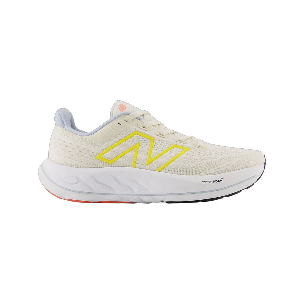 A white New Balance Vongo V6 running shoe with a yellow logo and fresh foam technology visible on the sole, designed for a cushioned ride.