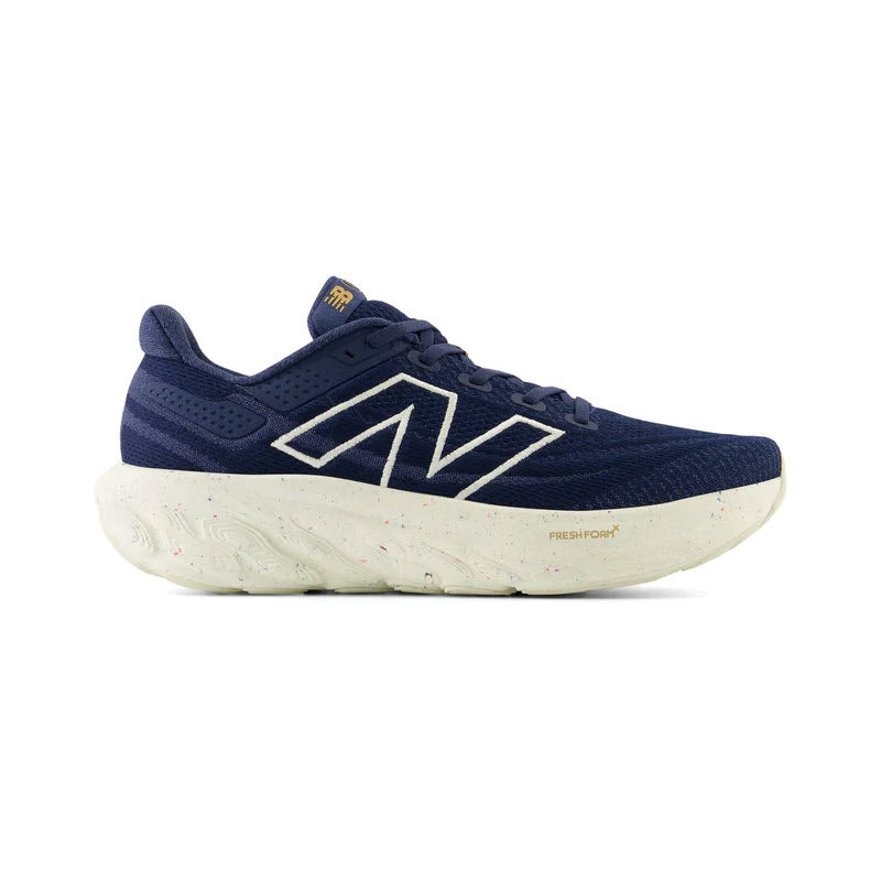 Side view of a navy blue New Balance 1080v13 running shoe with white midsole cushioning speckled with color.
