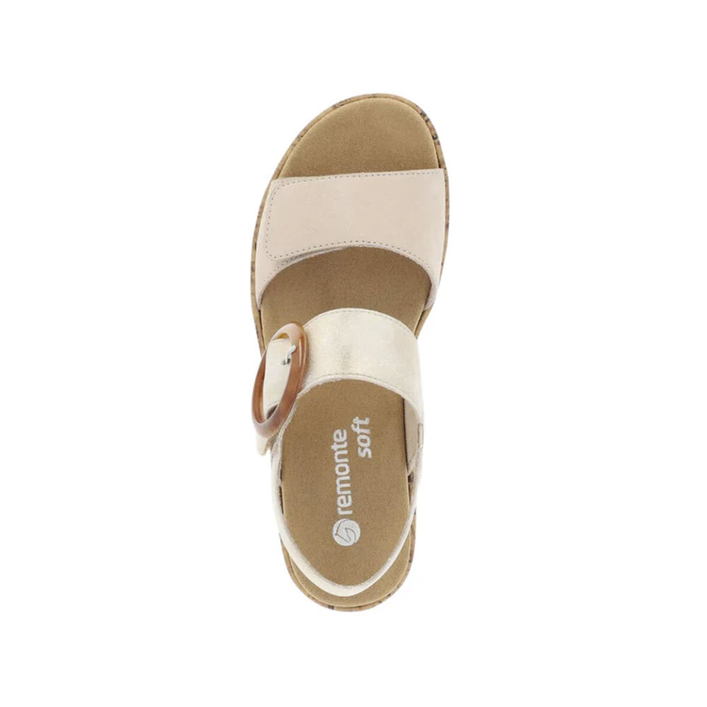 Top view of a beige Remonte Big Buckle Comfort Sandal Light Metallic women&#39;s sandal with a hook and loop fastener strap and soft insole, isolated on a white background.
