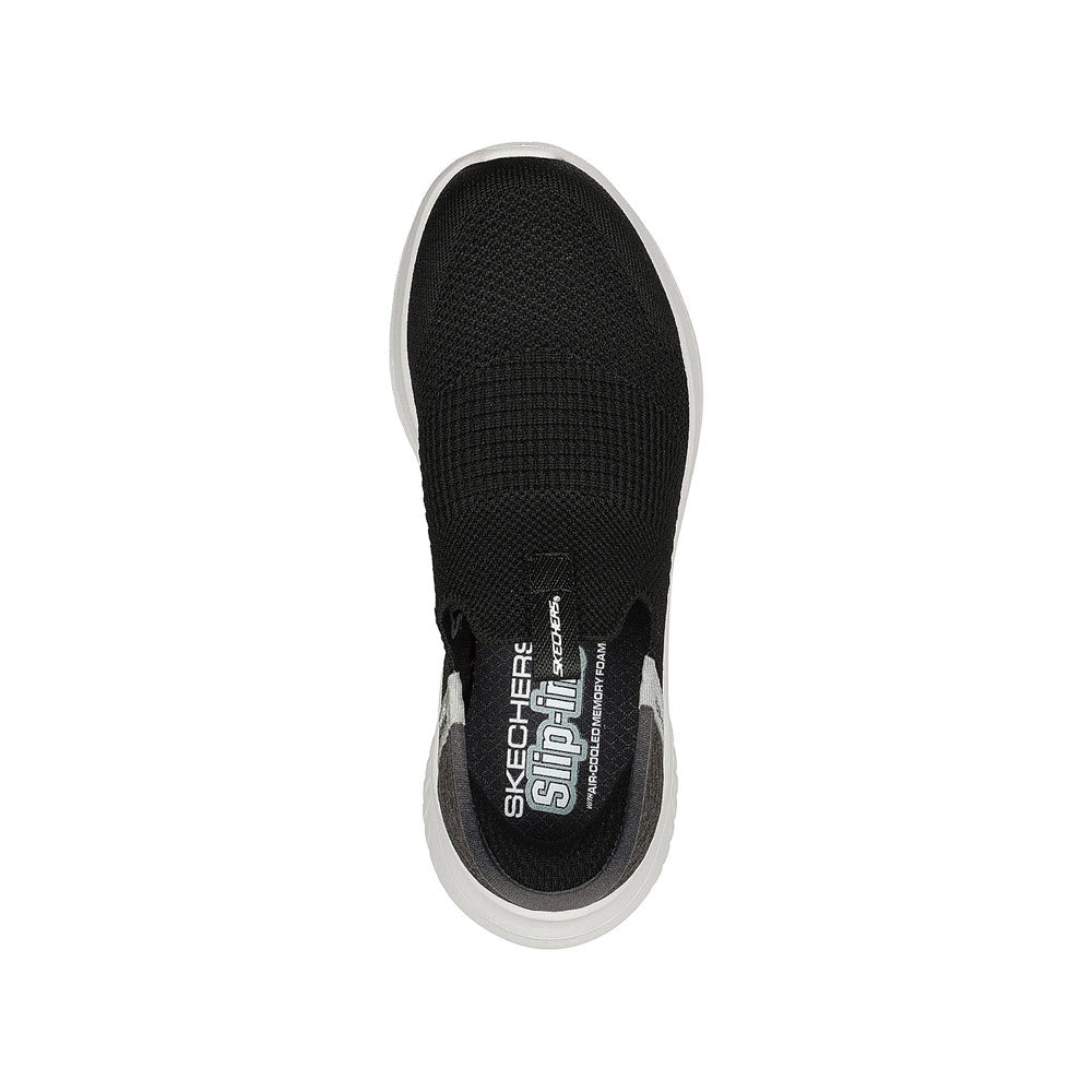 Top view of a black Skechers Slip Ins Ultra Flex 3.0 sneaker with a white sole, showcasing the brand&#39;s logo on the heel area.