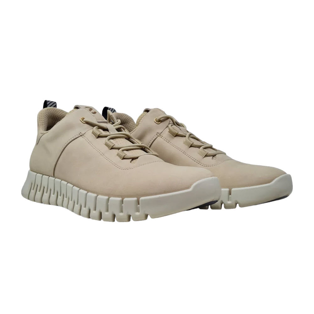 A pair of ECCO GRUUV M OXFORD SAND - MENS leather sneakers with lace-up fronts and thick, flexible rubber soles, isolated on a white background.