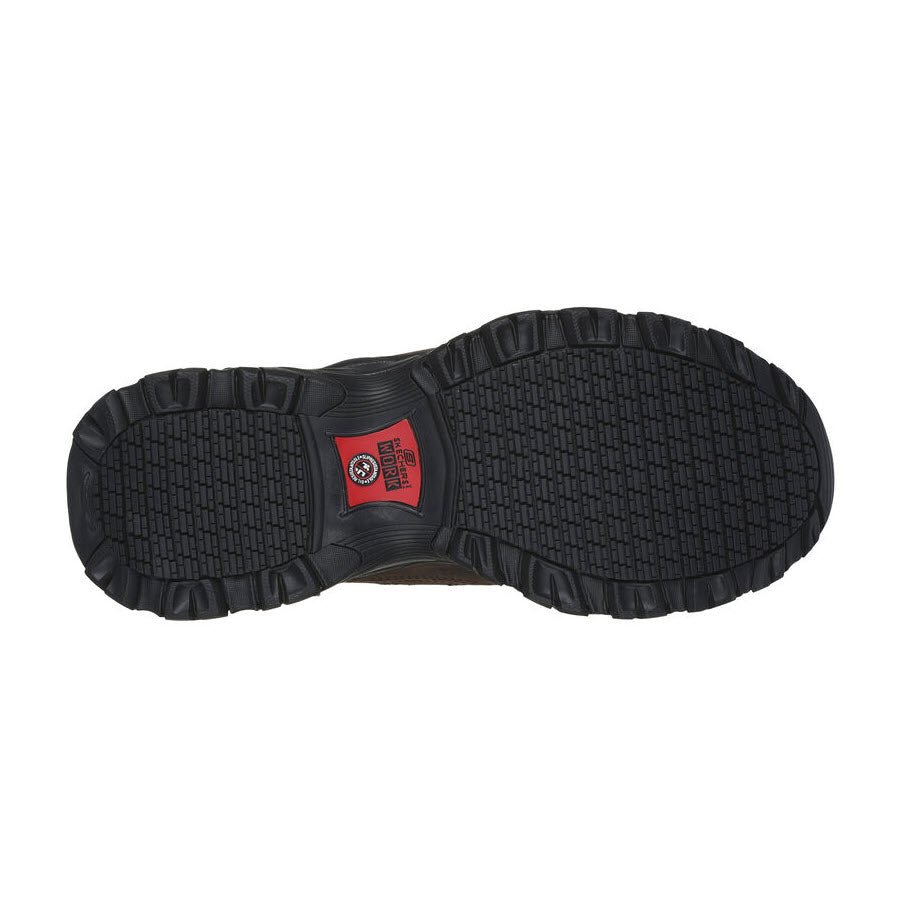 Bottom view of a pair of Skechers Safety Toe Holdredge Slip-Ins Crazy Horse Brown - Mens showcasing the textured soles with a visible red logo in the center, featuring Skechers Air-Cooled Memory Foam for enhanced comfort.