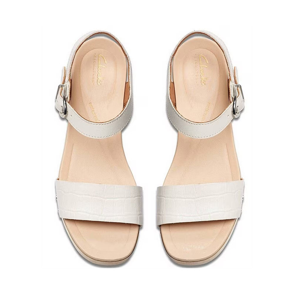 A pair of Clarks Sivanne Bay White Women&#39;s sandals with crocodile skin texture, featuring ankle straps and square toe, viewed from the top.