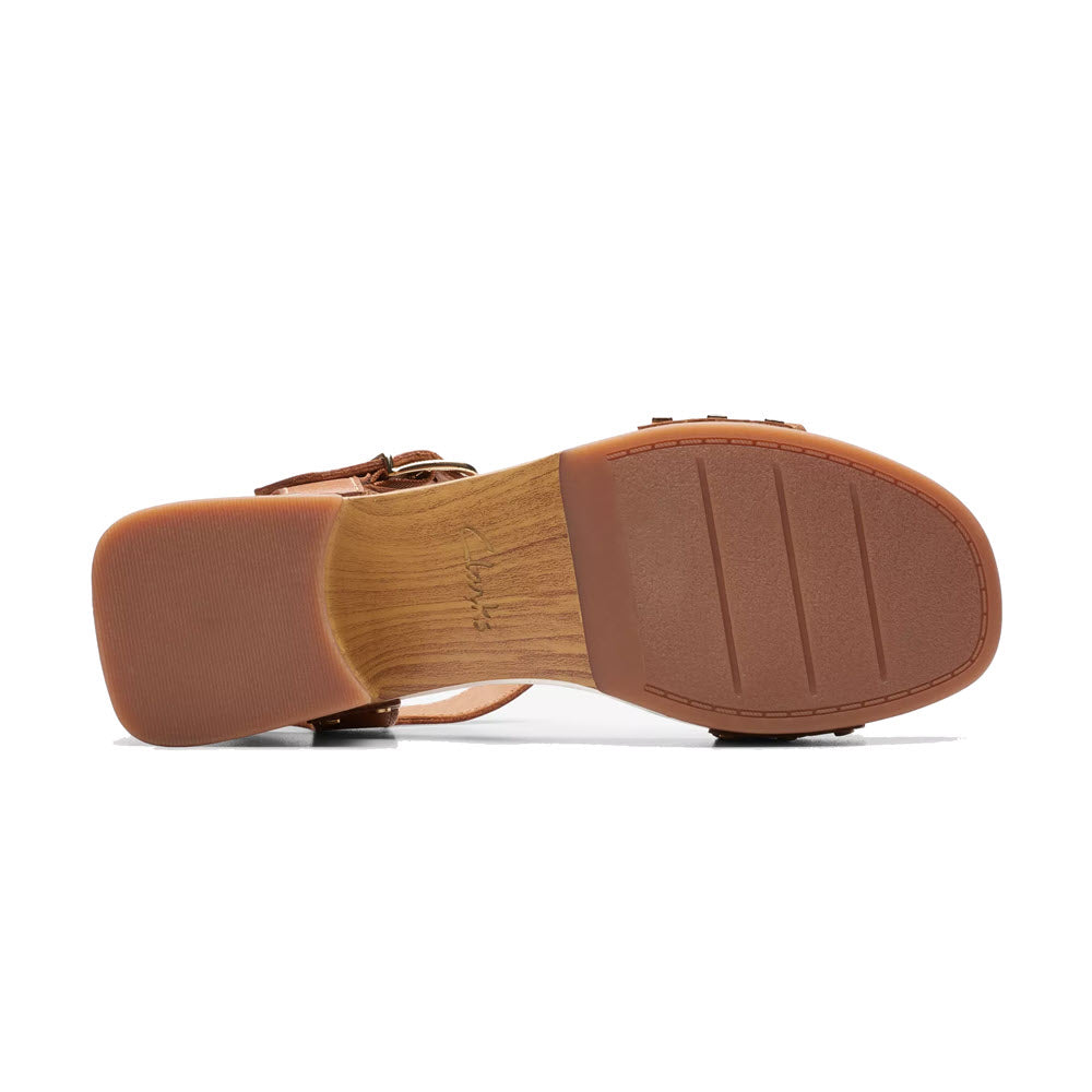 Brown leather Clarks Sivanne Walk Tan clog with buckled strap lying on its side, displaying the sole and flared heel.