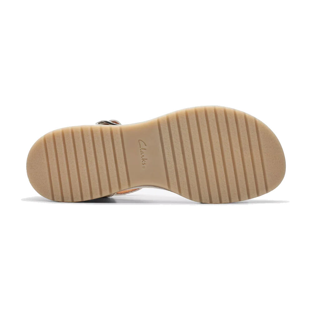 Bottom view of a Clarks Kassanda Lily sandal showing a tan sole with horizontal ridges and the Clarks brand name embossed in the center.