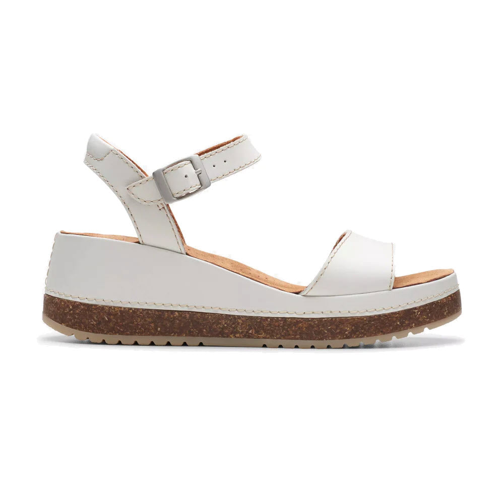 Off White Clarks Kassanda Lily sandal with cork-effect wedge heel, and an ankle strap, on a white background.