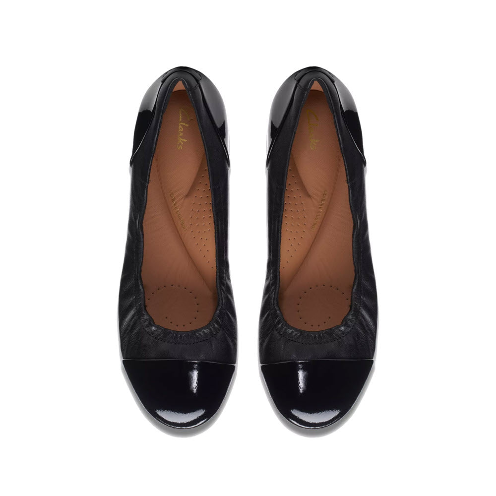A pair of Clarks Rena Jazz black patent leather ballet flats with rounded toes, displayed against a white background.