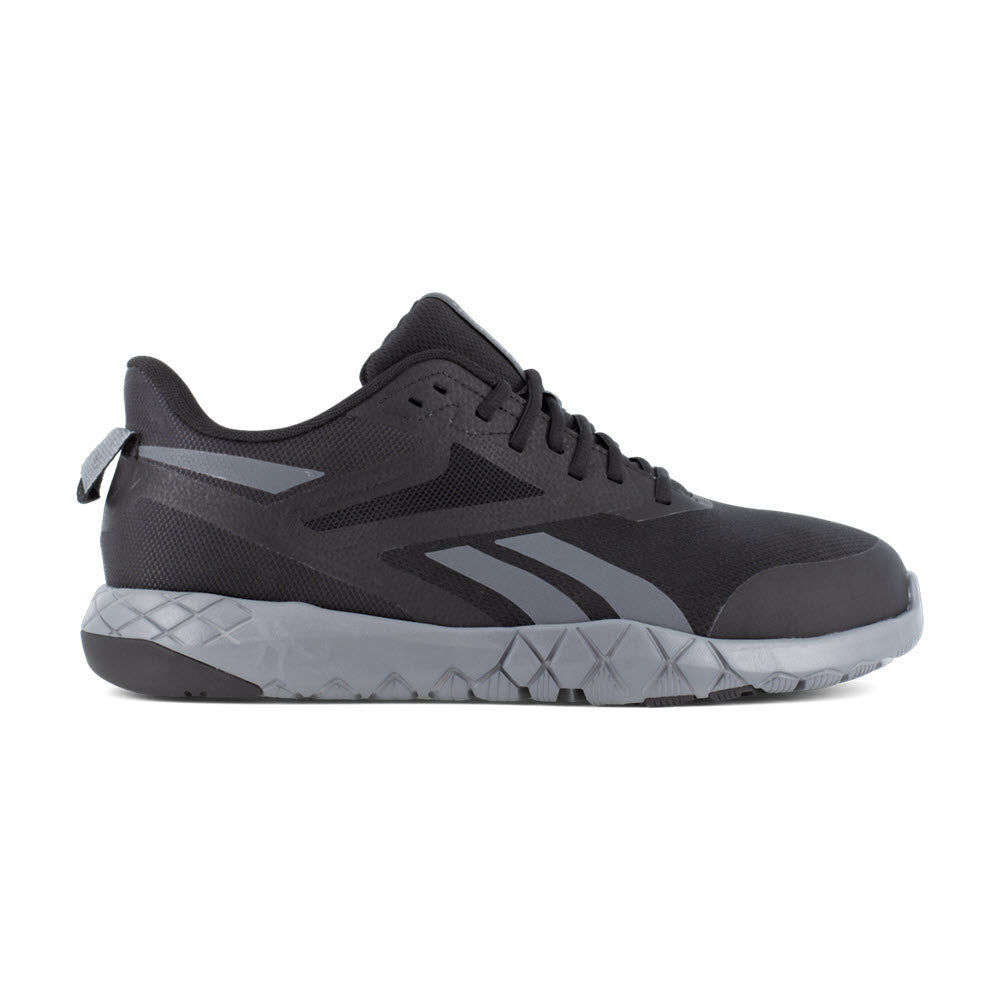 Black athletic sneaker with zigzag design and MemoryTech cushion footbed, shown in side profile on a white background, REEBOK COMPOSITE TOE FLEXAGON FORCE XL BLACK - MENS by Reebok Work.