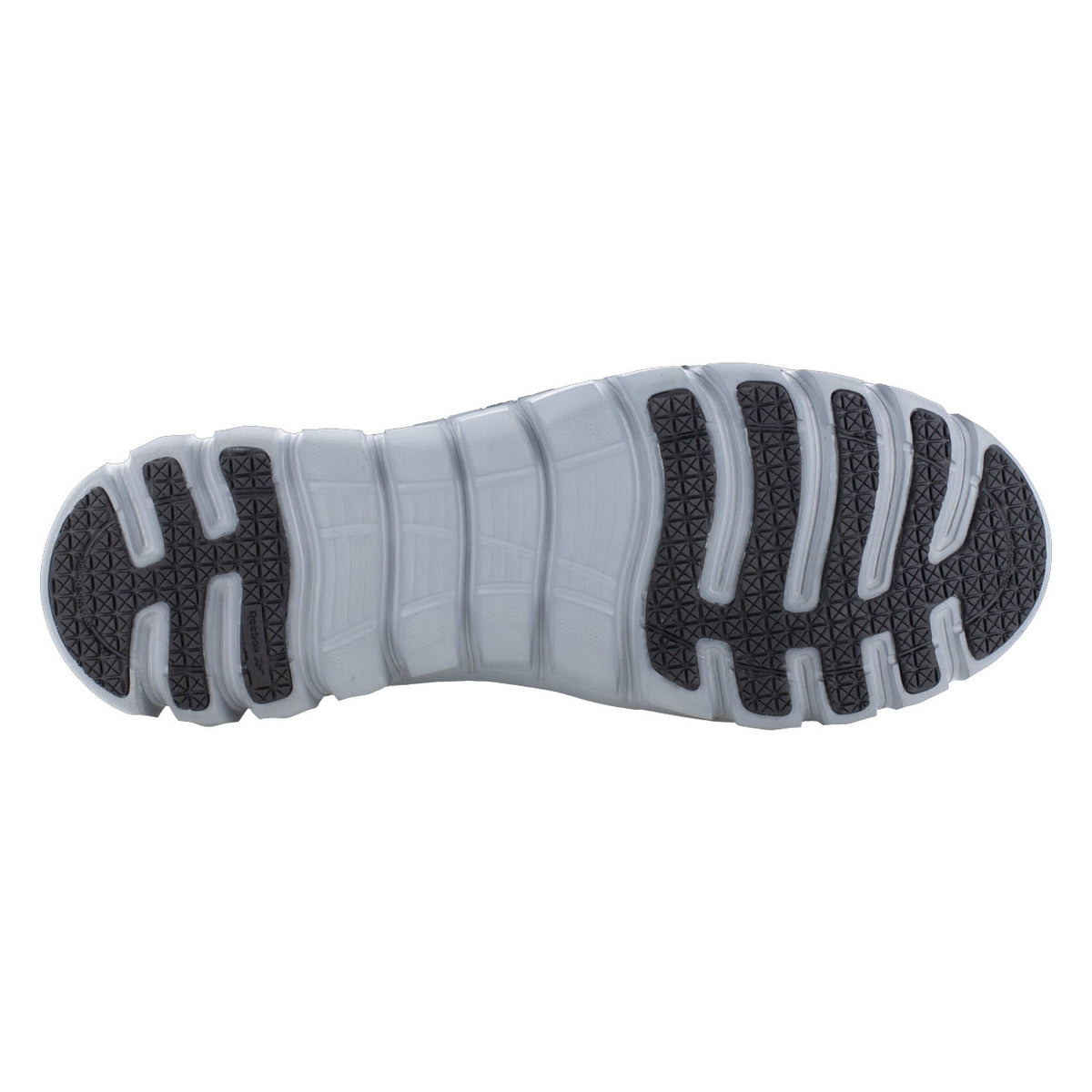 Bottom view of a Reebok Work shoe sole displaying a detailed tread pattern with alternating black and white sections on a MemoryTech Massage footbed.