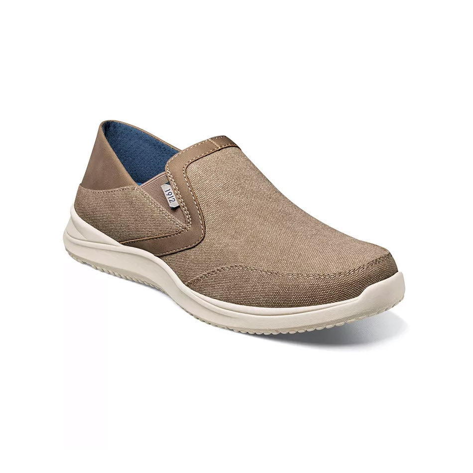 A Nunn Bush Conway EZ canvas moc toe slip-on shoe with a white sole and a small elastic side panel, displayed against a white background.