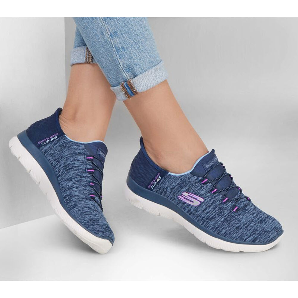 A person wearing blue Skechers Summits Dazzling Haze Navy/Purple Slip-ins paired with rolled-up jeans.