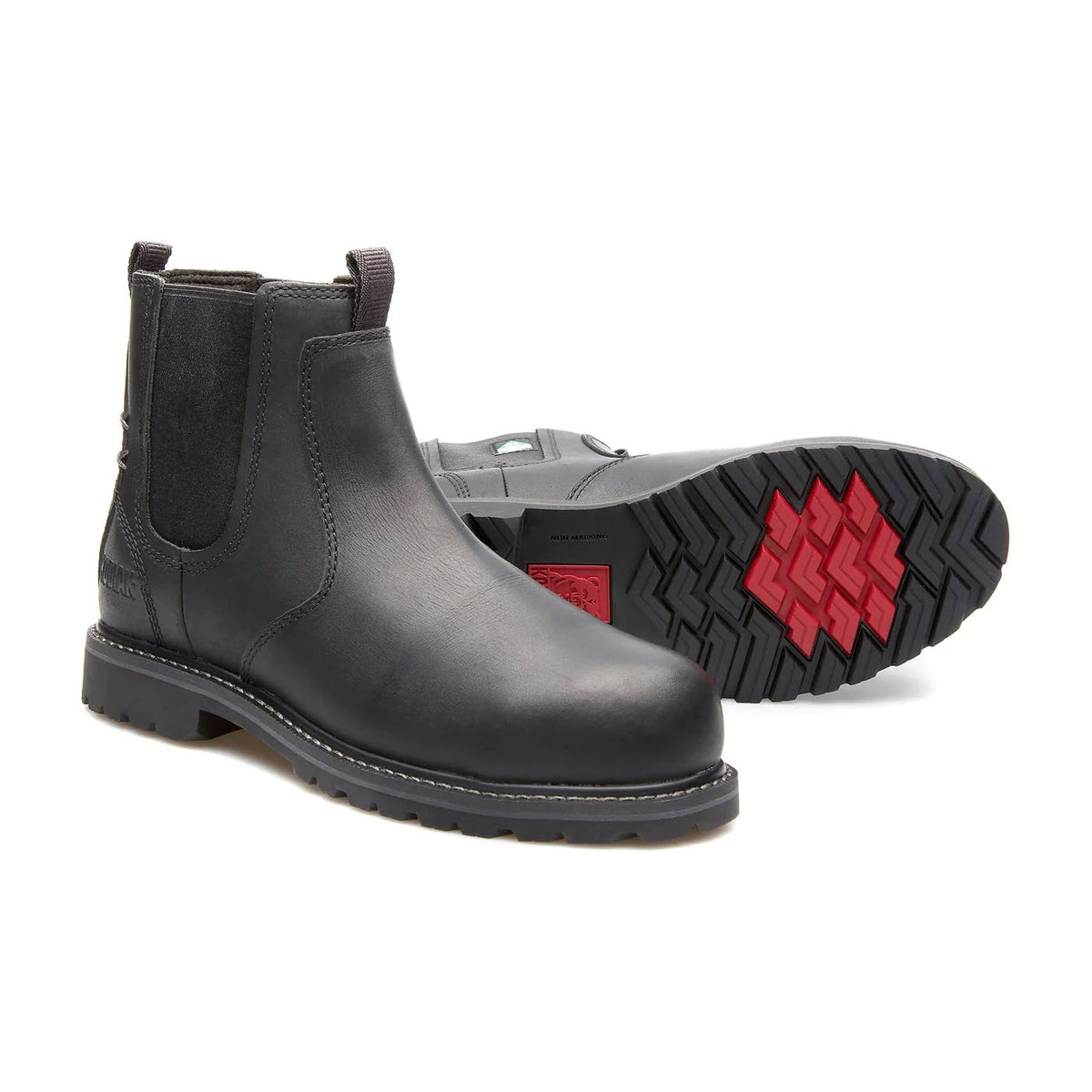 A pair of Kodiak Bralorne Chelsea black composite toe boots with elastic side panels and a distinctive red and black tread pattern on the sole, displayed on a white background.
