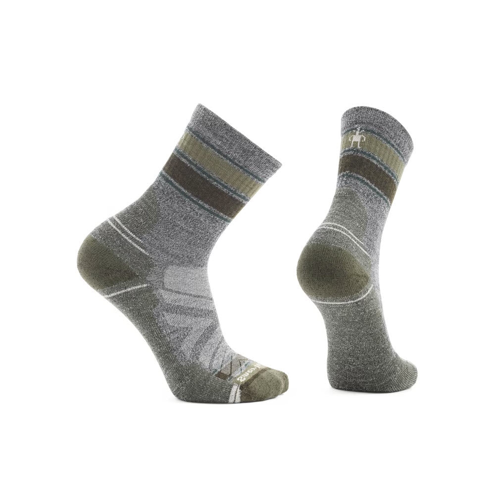 Discover the SMARTWOOL HIKE STRIPE MID CREW SOCKS in Ash/Charcoal, designed for men by Smartwool. These socks come in grey and green with eye-catching striped patterns and prominent branded logos. Crafted with Indestructawool technology, they offer enhanced durability. One sock stands upright while the other is positioned to reveal the heel and sole, highlighting its 4 Degree Elite Fit System for a snug fit during every hike.