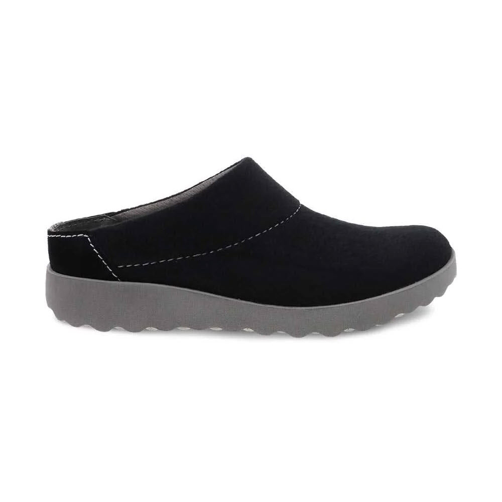 Dansko Lucia black slip-on shoe with a low heel and contrast stitching, featuring Natural Arch technology, displayed on a white background.