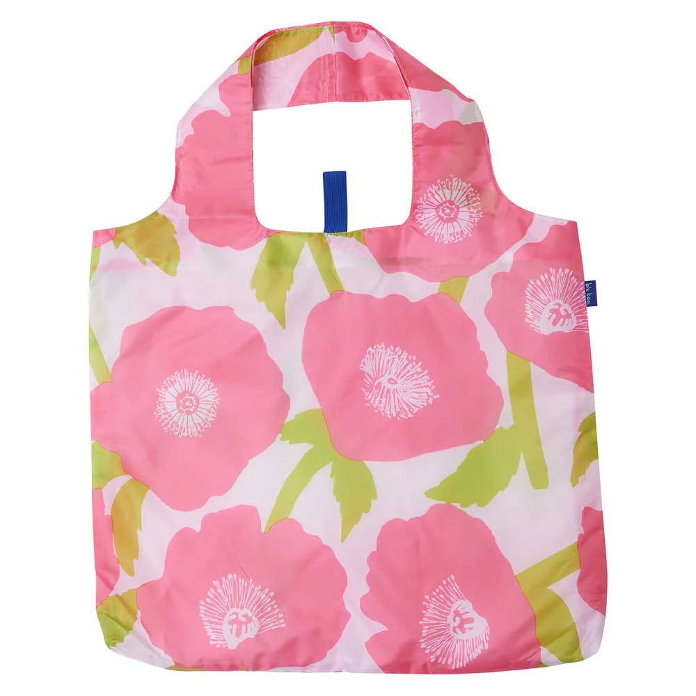 A Rockflowerpaper BLU BAG POPPIES PINK reusable shopping bag with a floral pattern featuring large pink and white flowers and green leaves on a white background, also serving as a packable spare bag for travel.