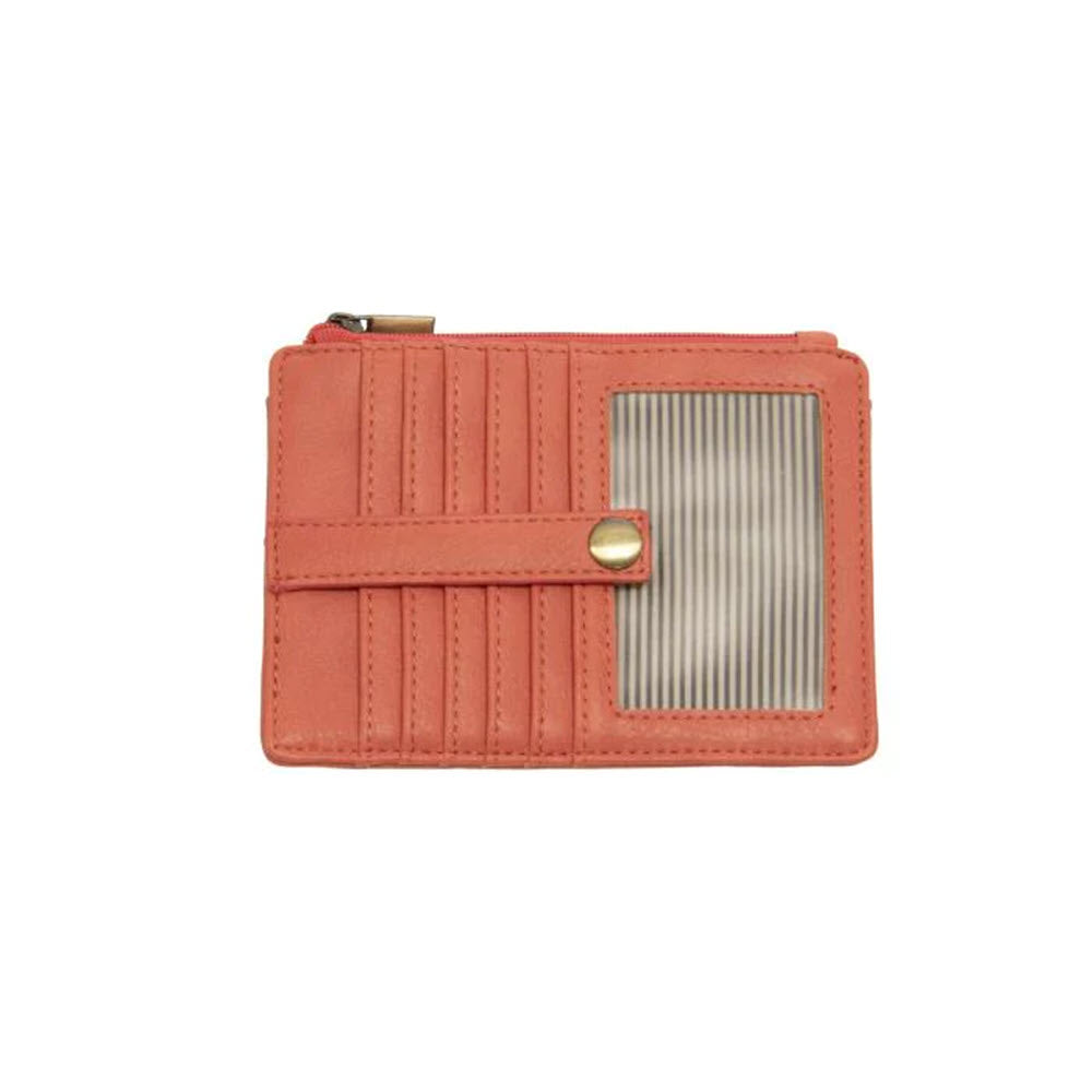 A Joy Susan Penny Mini Wallet Coral, a coral-colored vegan leather wallet with a ribbed texture and a metallic clasp, featuring multiple compartments and a zipper pocket.