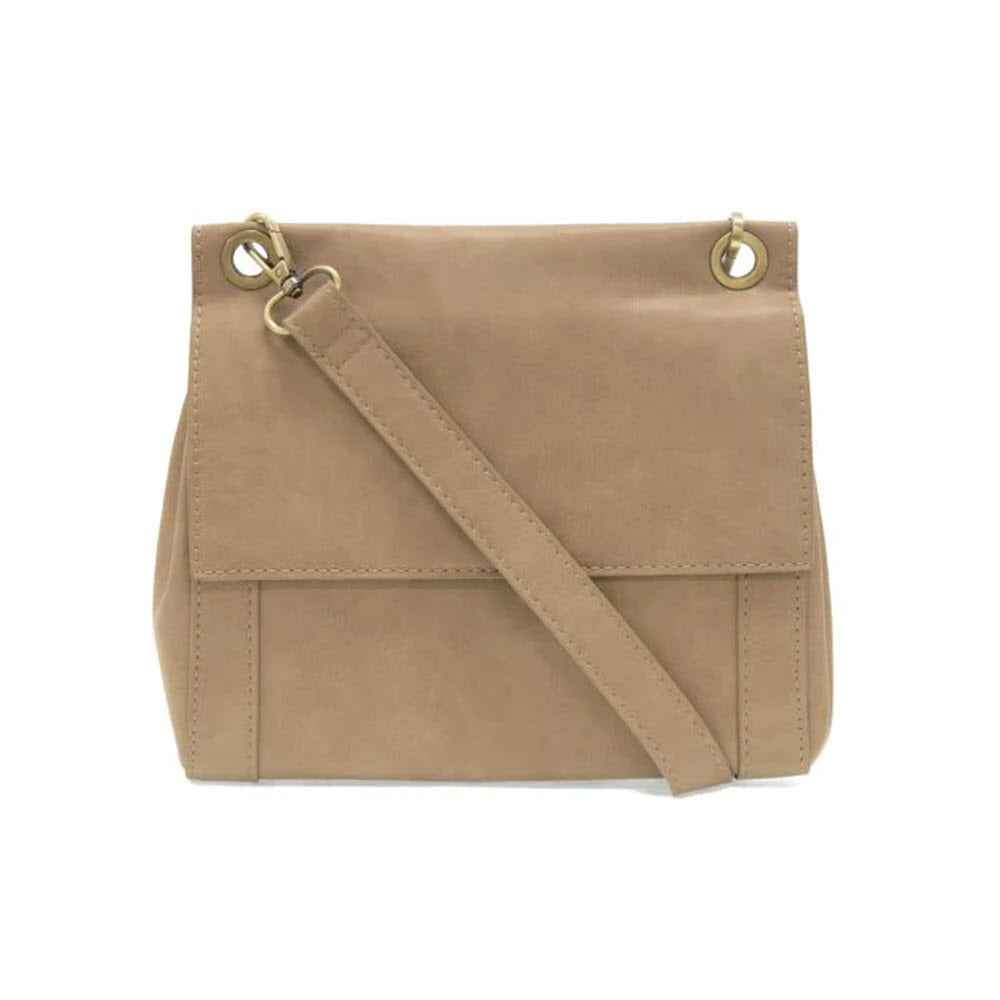 A beige vegan leather Joy Susan Liana crossbody bag in driftwood color with a flap closure and adjustable shoulder strap, displayed against a white background.