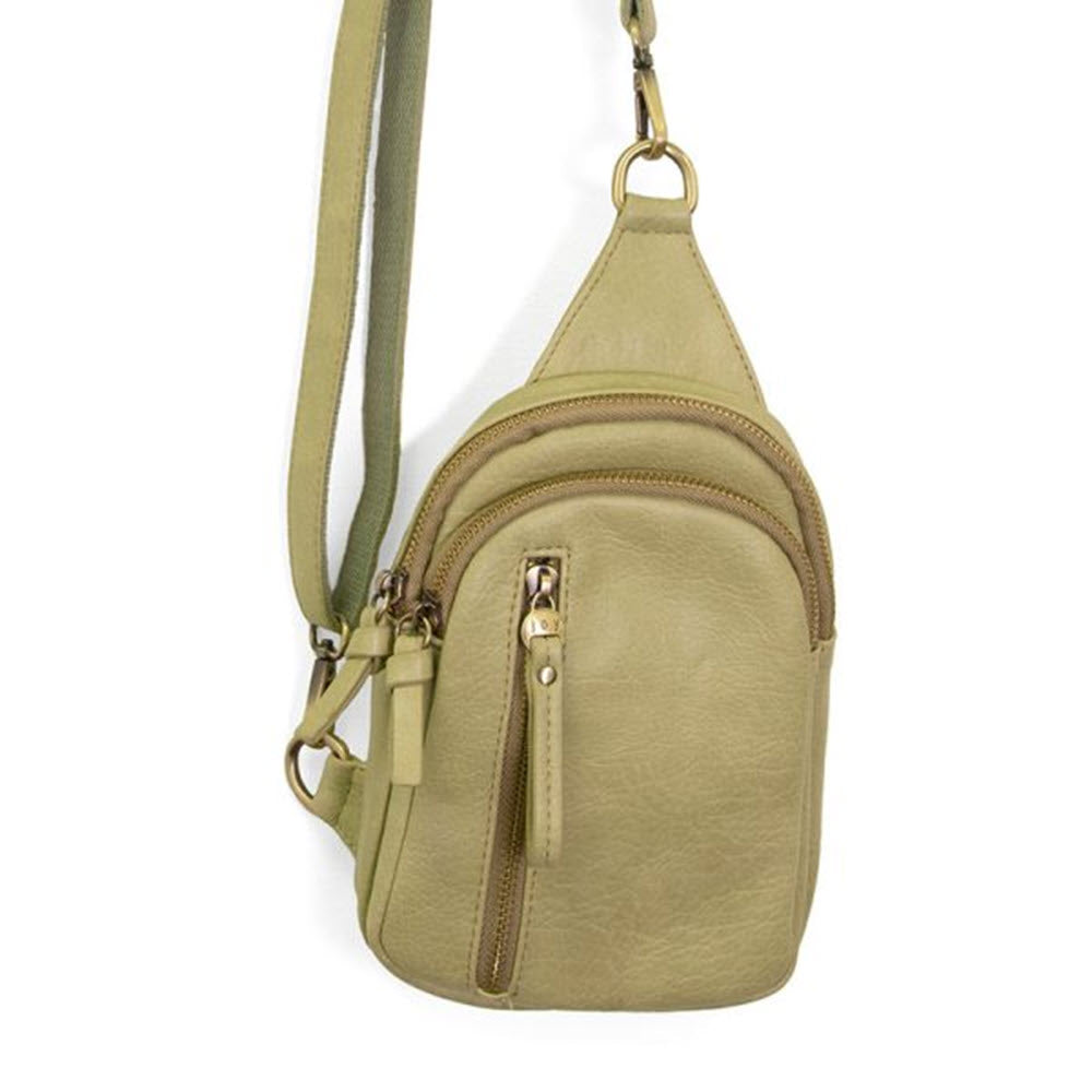 Joy Susan Skylar Sling Sage vegan leather sling bag with multiple zippers, isolated on a white background.