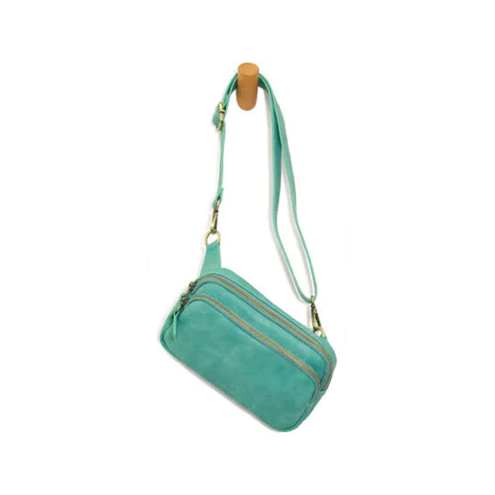 A JOY SUSAN KYLIE BELT BAG TURQUOISE with a convertible strap and gold-tone hardware, isolated on a white background.
