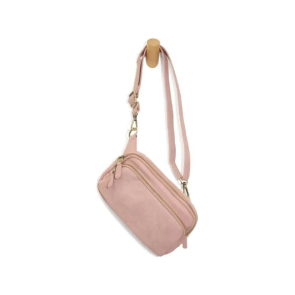 A small pink Joy Susan Kylie belt bag with a gold zipper and an adjustable strap, displayed against a plain white background.