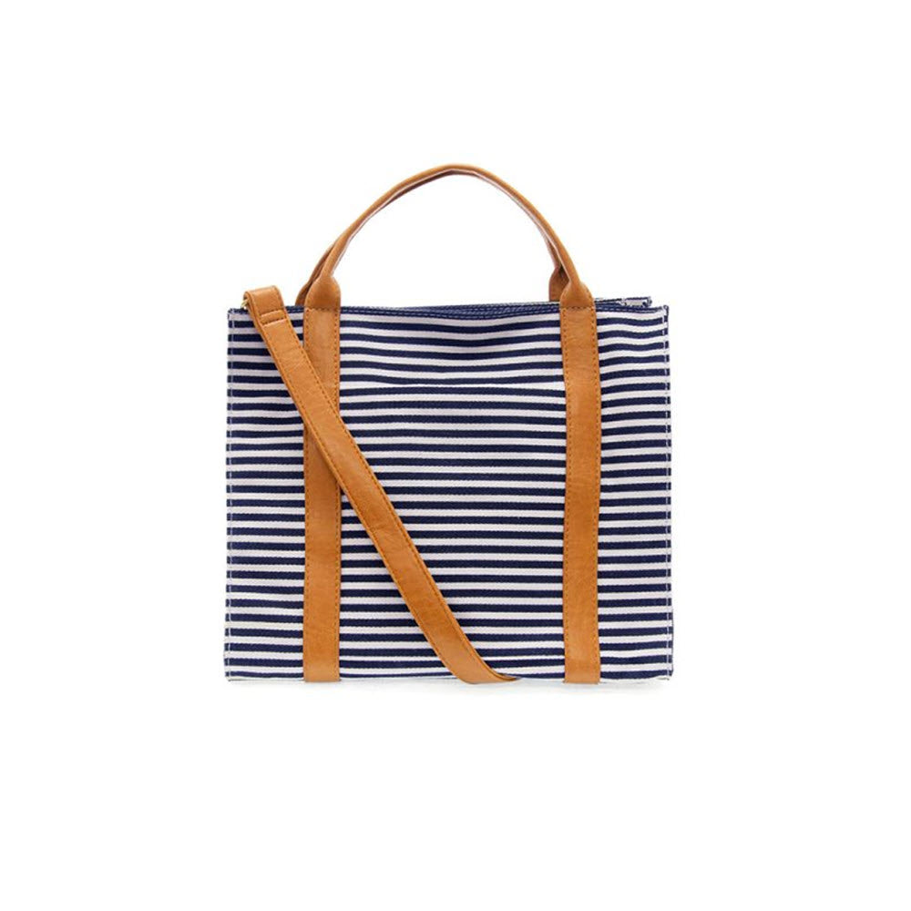 JOY SUSAN Toni Large Canvas Tote in Navy/White with brown vegan leather handles on a white background.