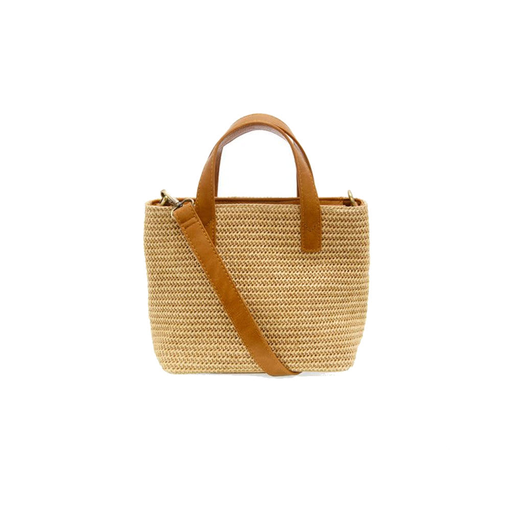 A small woven Joy Susan Sierra tote with a tan leather shoulder strap and matching handles, displayed against a white background.
