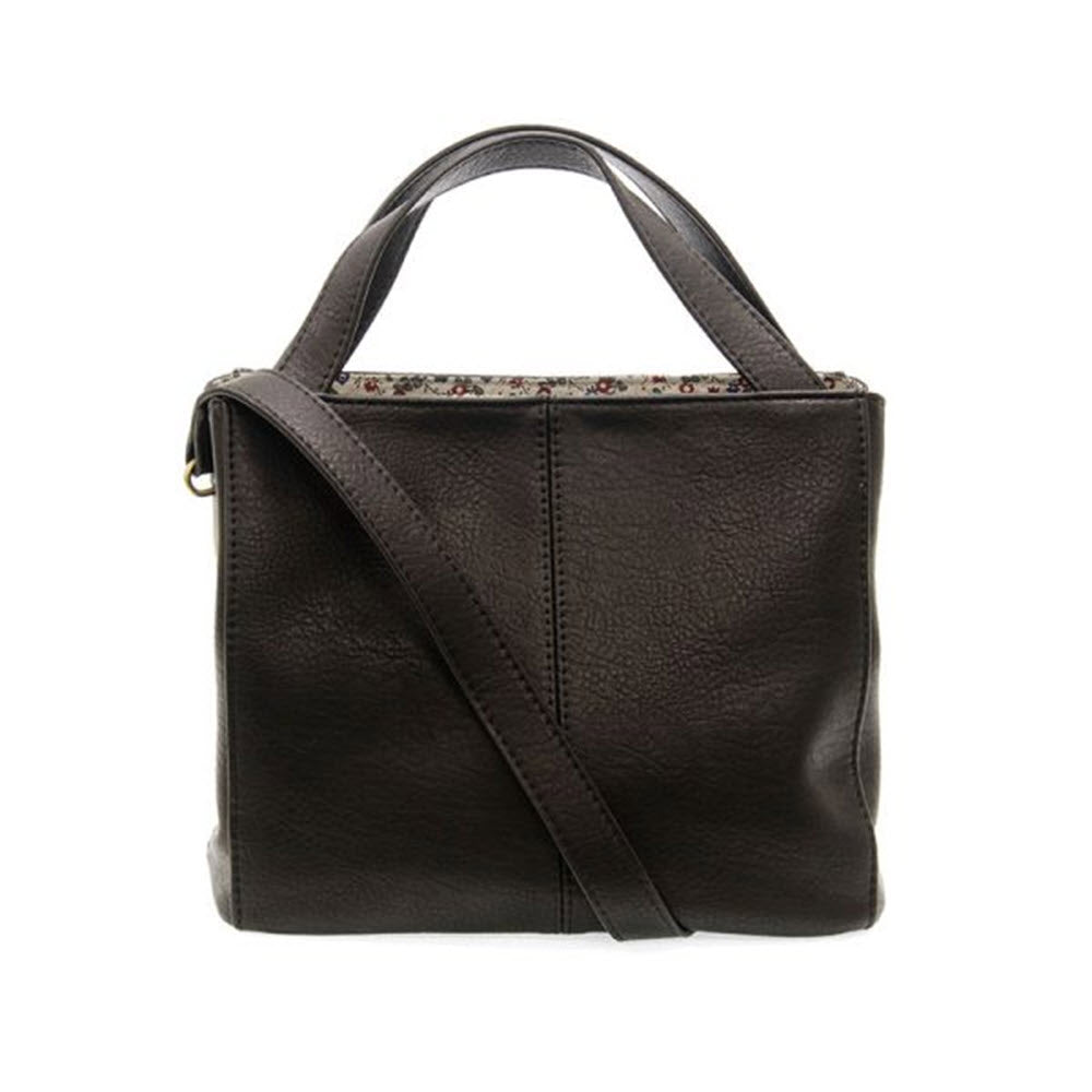 A Joy Susan Brandi Crossbody Black vegan leather handbag with a floral lining visible at the top, featuring a crossbody strap and a top handle.