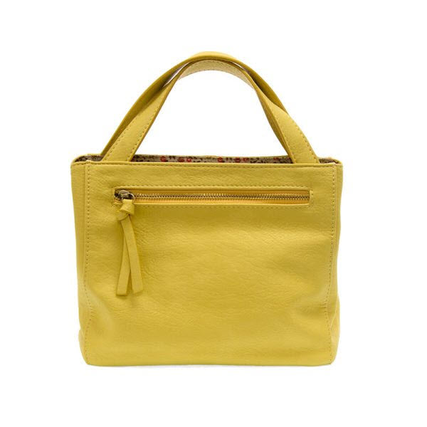 Joy Susan yellow vegan leather crossbody tote bag with a front zipper and tassel on a white background.