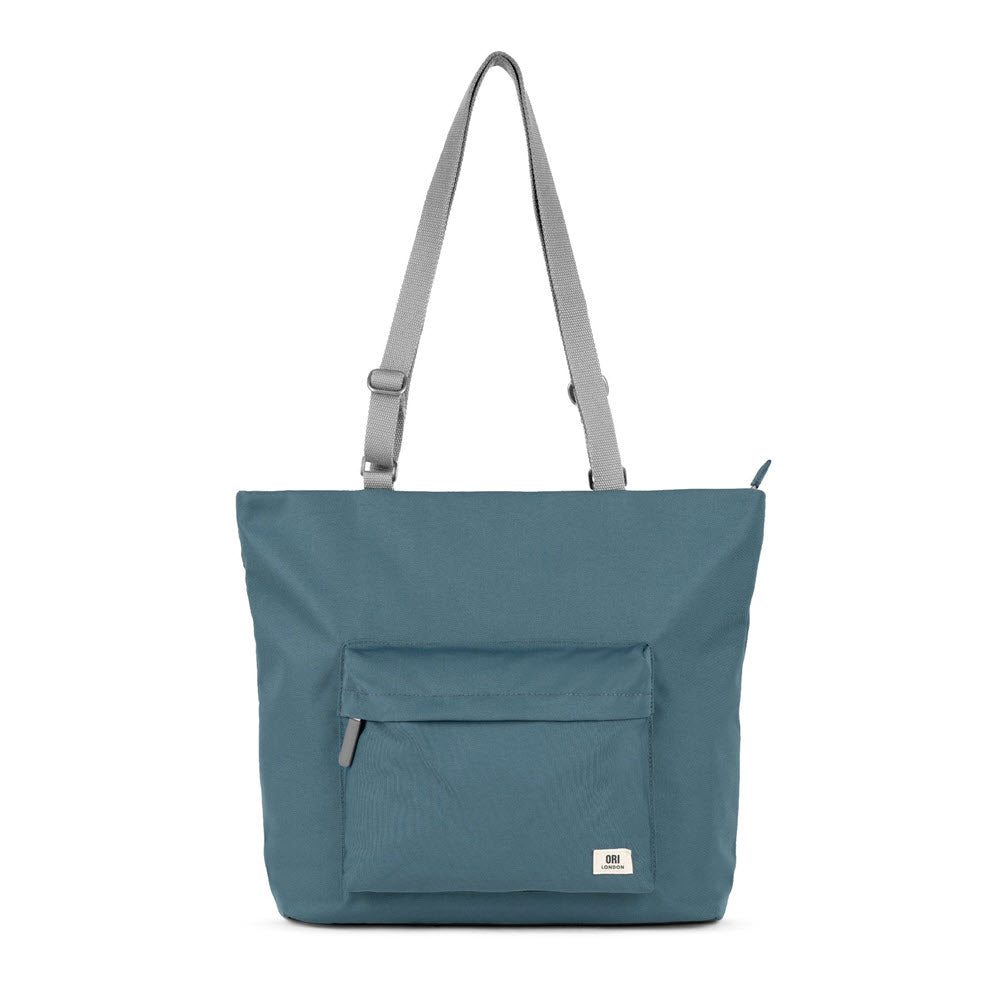 A Ori London Trafalgar B tote bag with a front zipper pocket and an adjustable strap, isolated on a white background.