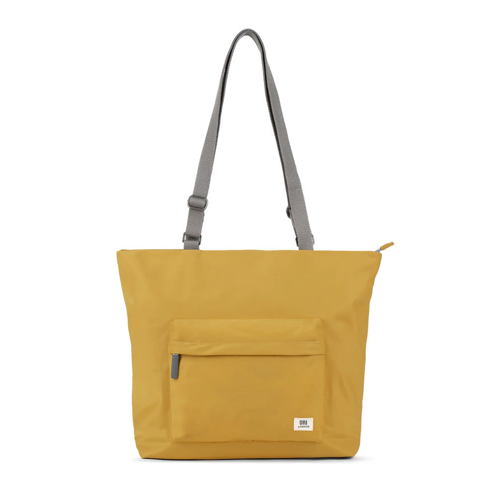 A mustard yellow Ori London Trafalgar tote with a gray adjustable strap and an external laptop pocket, isolated on a white background.