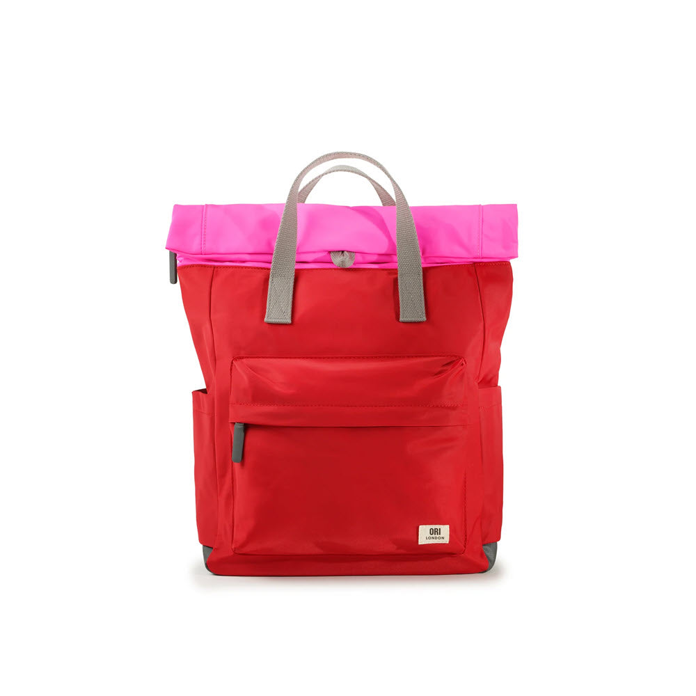 A bright red Ori London roll-top backpack with a pink top flap and gray handles, featuring a front pocket and a visible brand logo on the lower right corner.