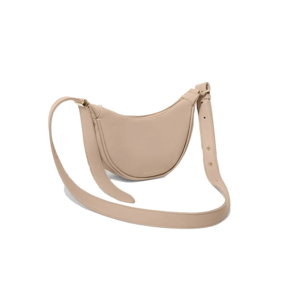 Beige Katie Loxton Harley Sling Bag made of vegan leather, featuring an adjustable crossbody strap, on a white background.