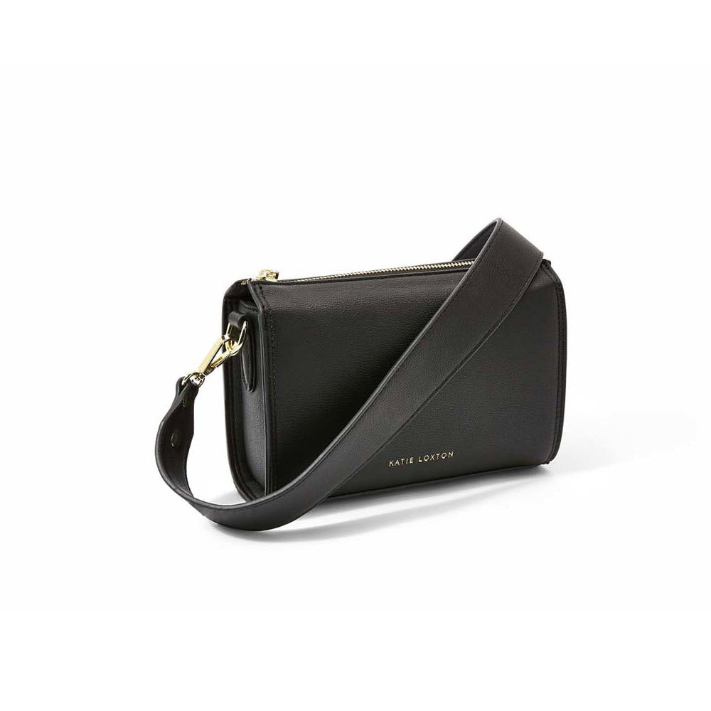 A black Katie Loxton Zana Mini Crossbody Bag with a zipper and a detachable crossbody strap, displayed against a white background.