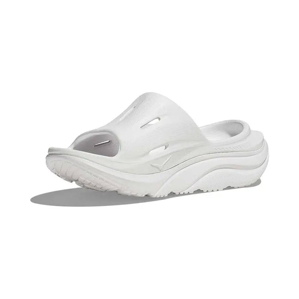 White HOKA ORA Recovery Slide 3 slip-on sandal with holes on top and a thick sole, featuring a sustainable sugarcane footbed, against a plain white background.
