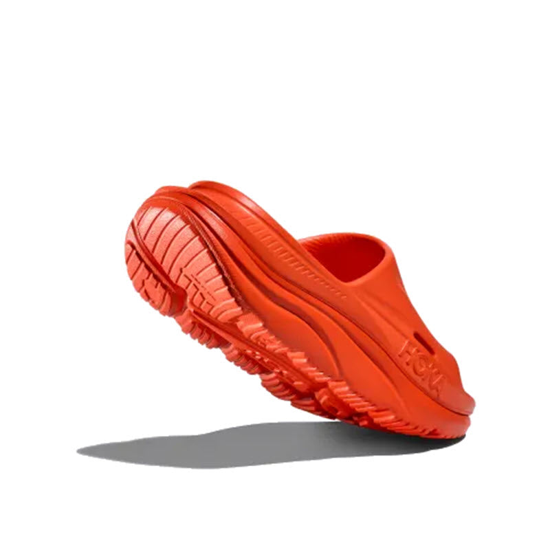 Bright orange HOKA ORA RECOVERY SLIDE 3 VIBRANT ORANGE with a thick, textured sole isolated on a white background.