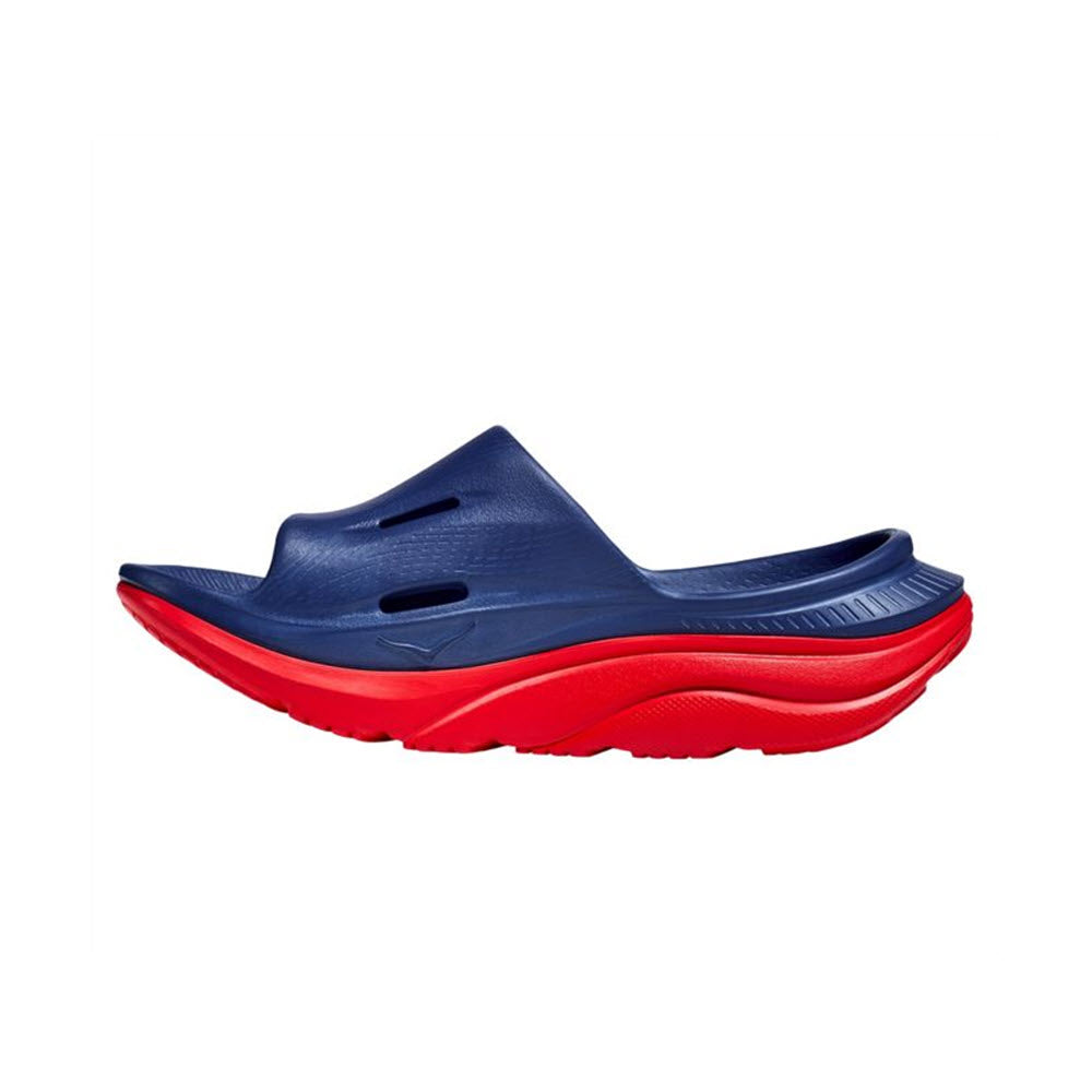 A blue and red Hoka ORA Recovery Slide 3 sports recovery sandal with a sugarcane footbed isolated on a white background.
