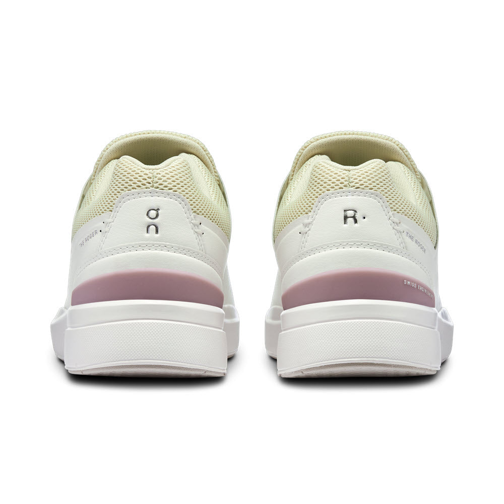 Rear view of a pair of ON THE ROGER ADVANTAGE WHITE/MAUVE - WOMENS sneakers with CloudTec cushioning, showing &quot;l&quot; and &quot;r&quot; on the respective heel tabs, against a white background.