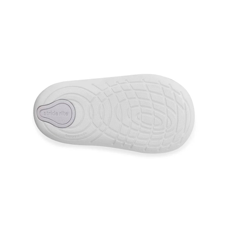 A close-up view of the bottom of a white leather Stride Rite SM Lucianne Iridscent - Kids shoe, showcasing its textured sole design.
