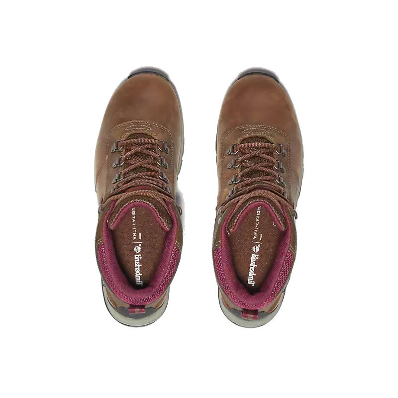 A pair of Timberland MT. Maddsen Mid Waterproof Medium Brown hiking boots with red laces and a visible pink interior, viewed from above.