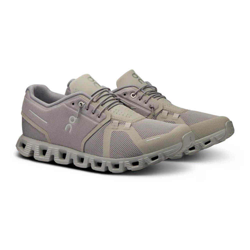 A pair of On Running ON CLOUD 5 FOG/ALLOY - MENS sneakers featuring a speed lacing system and a unique, segmented sole, displayed on a white background.