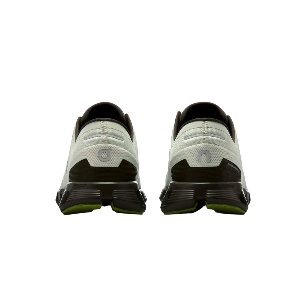 Rear view of two gray On Running Men&#39;s ON CLOUD X 3 ICE/ECLIPSE shoes with black and lime accents, featuring distinct branding on the heel.