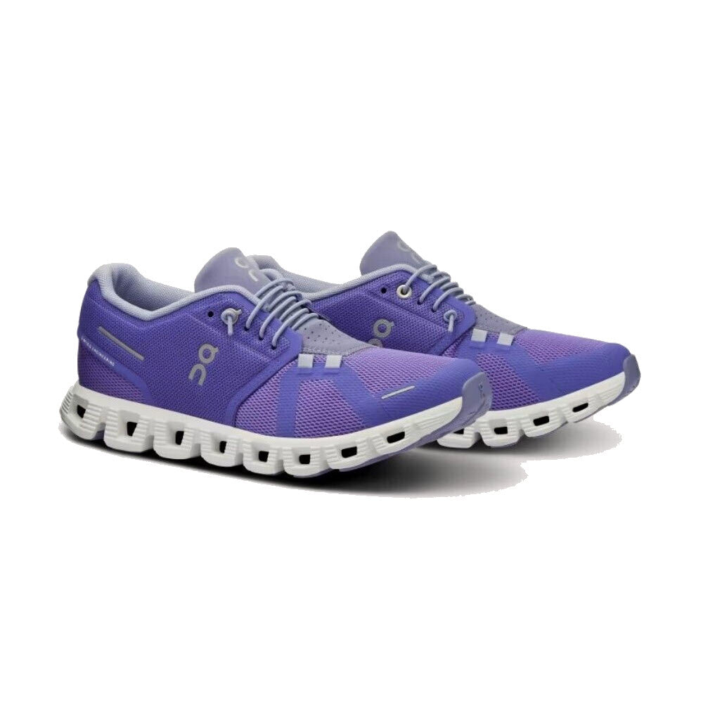A pair of ON RUNNING CLOUD 5 BLUEBERRY/FEATHER - WOMENS athletic shoes with white laces and a distinctive white sole, designed for all-day comfort, displayed against a white background.