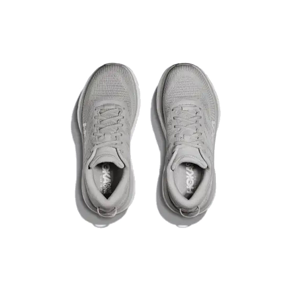 A pair of gray Hoka HOKA BONDI 7 HARBOR MIST - WOMENS road shoes with laces, featuring Meta-Rocker technology for a smooth ride, viewed from above against a white background.