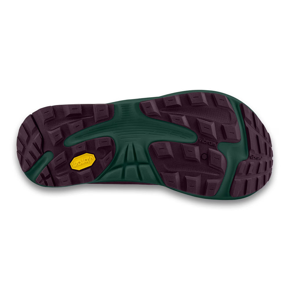 The image shows the treaded sole of the TOPO ULTRAVENTURE 4 PURPLE/DARK TEAL - WOMENS trail runner by Topo, featuring a dark green and maroon rubber sole with a yellow Vibram® XS Trek EVO logo near the heel.