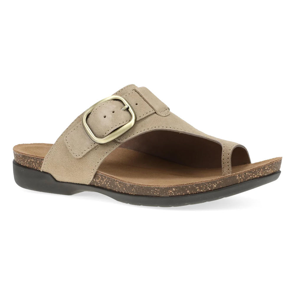 The Dansko Rylee Sand womens sandal features tan suede, a wide strap with a large gold buckle, open toe, cork footbed, and black rubber sole for comfort. Shown on a white background.