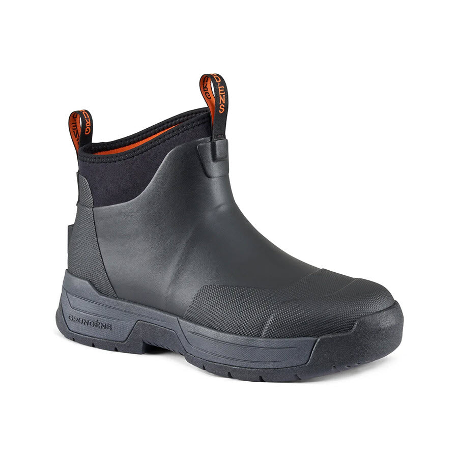 The GRUNDENS TOUGH SEAS ANKLE BOOT BLACK - MENS by Grundens is a slip-resistant ankle boot designed for rugged environments, featuring orange accents and pull tabs.