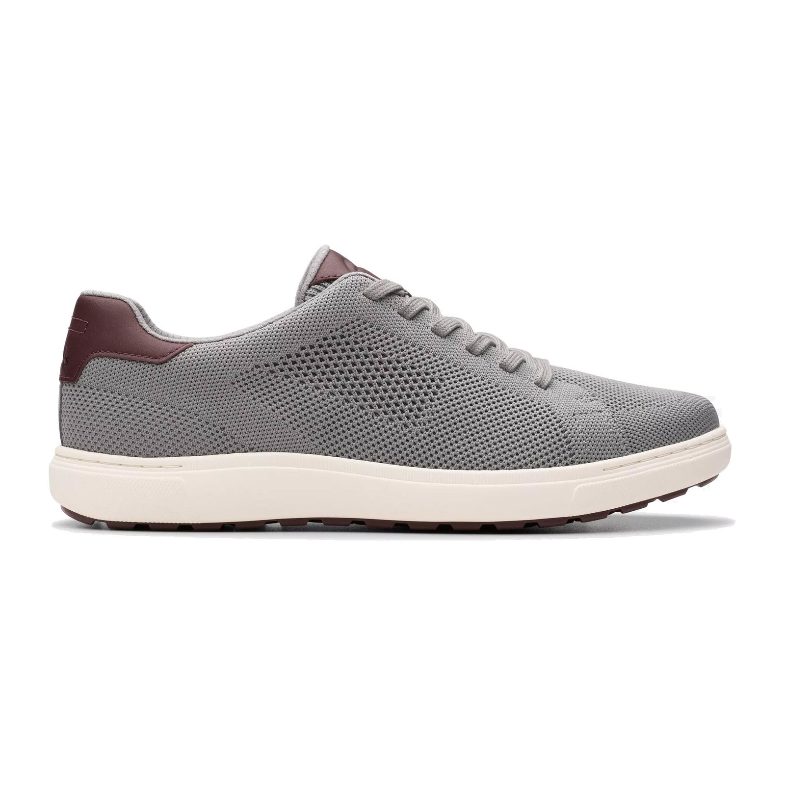 The CLARKS MAPSTONE LACE GRAY KNIT sneaker for men by Clarks features a gray knit upper, white sole, brown heel and tongue accents, and a lightweight rubber outsole for comfort and cushioning, shown in side profile on a white background.