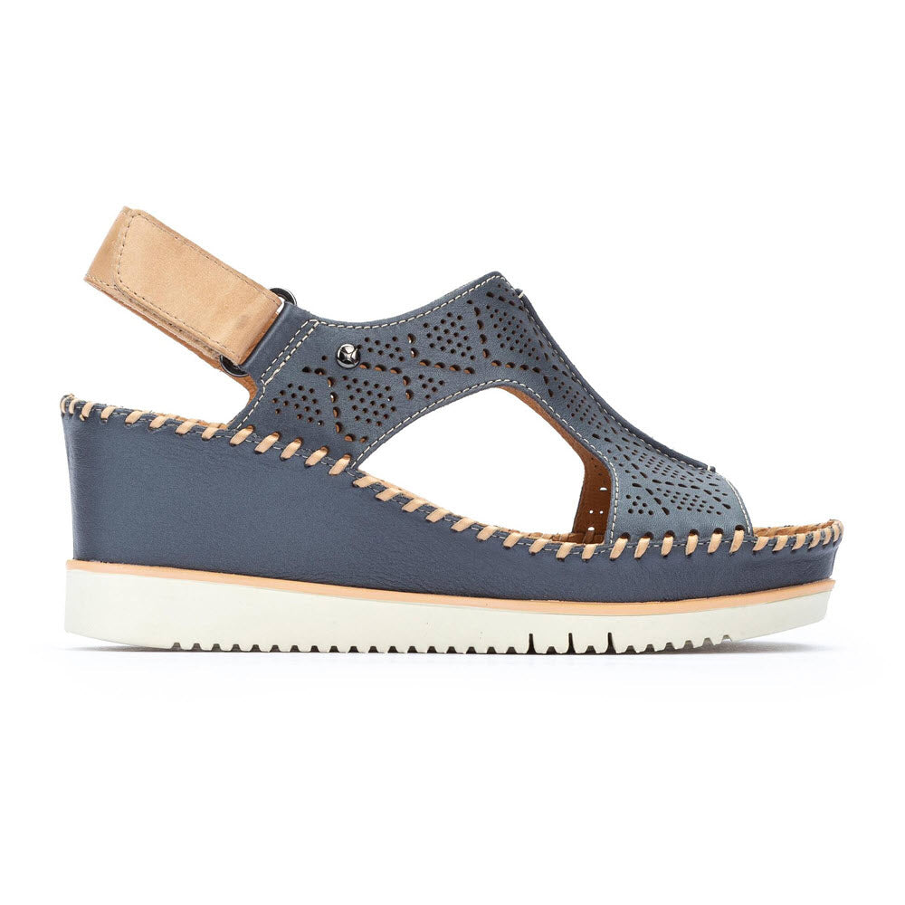 The Pikolinos Aguadulce Blue womens wedge sandal features a Mediterranean-inspired cutout design, tan heel strap, white sole, visible stitching, and Velcro closure—blending style and comfort by Pikolinos.